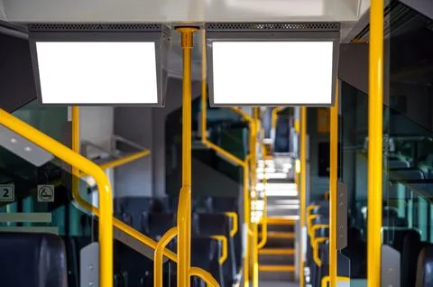 Blank interior view of a bus showing handles and empty seats during the day Photos