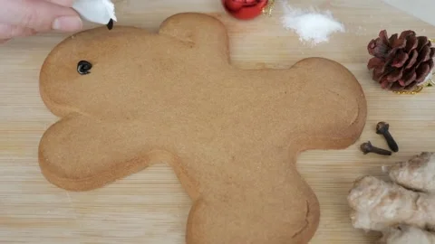 Blank large gingerbread cookie on wooden board being decorated with coloured 動画素材 341499679