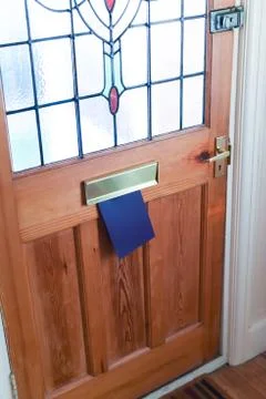 Blank leaflet or flyer being posted through a letter box unwanted junk mail Stock Photos