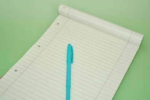 Blank Lined Notepad with Cyan Pen on Pastel Green Background Stock Photos
