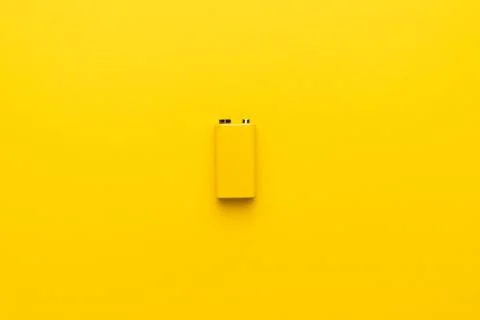 Blank nine-volt battery on the yellow background Stock Photos