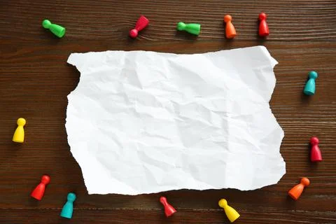 Blank note and game pieces on wooden table, flat lay. Space for text Stock Photos