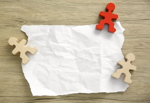 Blank note and human figures on wooden table, flat lay. Space for text Stock Photos