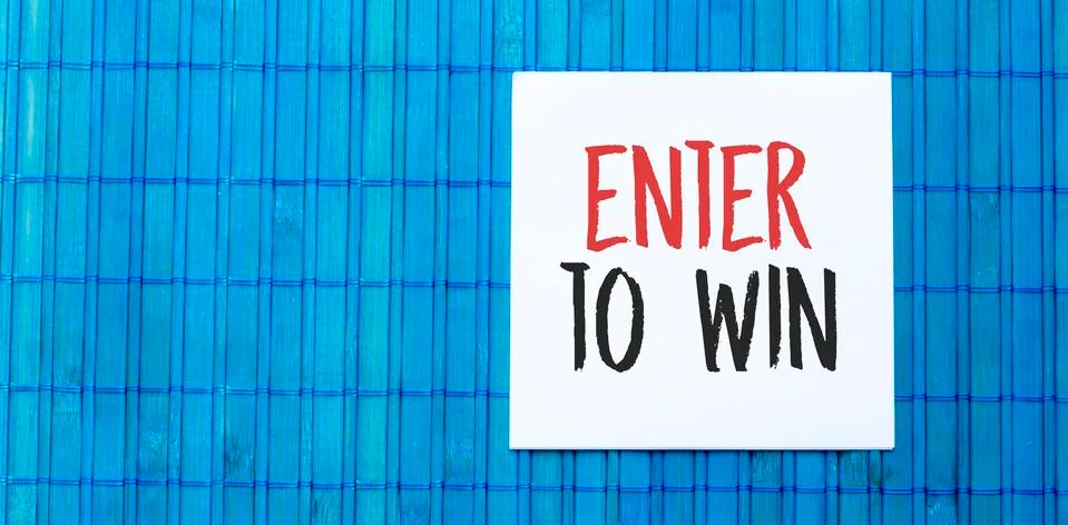 Blank note pad with enter to win text on blue wooden background Stock Photos