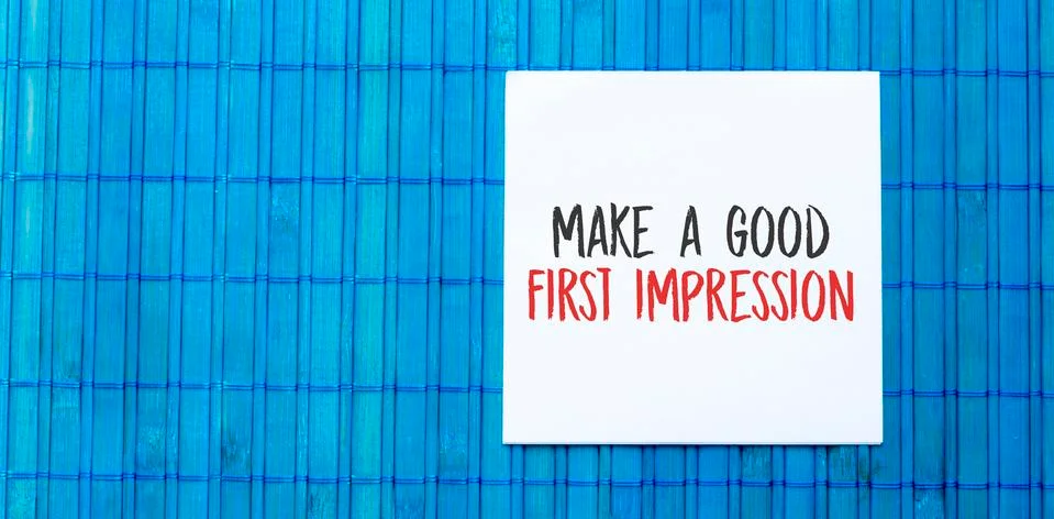 Blank note pad with MAKE A GOOD FIRST IMPRESSION text on blue wooden backgrou Stock Photos