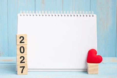 Blank notebook and 2027 cubes with red heart shape decoration on blue woode.. Stock Photos
