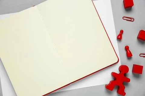 Blank notebook and human figure on light grey background, flat lay. Space f.. Stock Photos