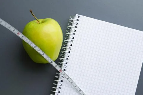 Blank notebook with apple and measuring tape Foto stock