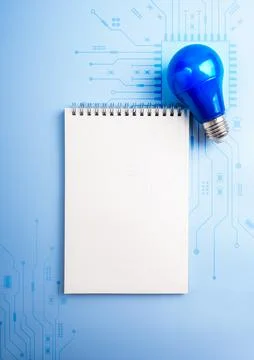 Blank notebook with blue light bulb on AI circuit background. Creative thin.. Stock Photos