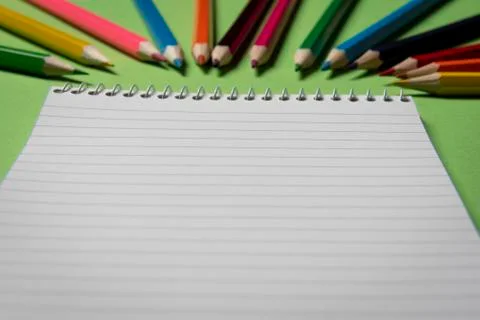 Blank notebook close up with colored pencils in background Stock Photos
