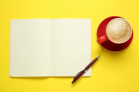 Blank notebook, coffee and pen on yellow background, flat lay. Space for text Stock Photos