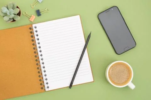 Blank notebook with empty page, coffee cup and hand holding a pencil. Table t Foto stock