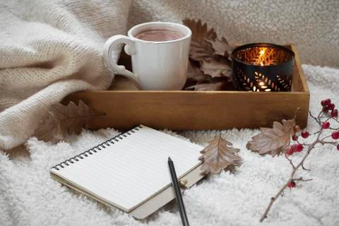 Blank notebook with mug of coffee on warm cotton fabric Stock Photos