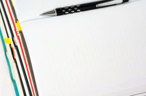 Blank notebook open on stack of book with pen Stock Photos