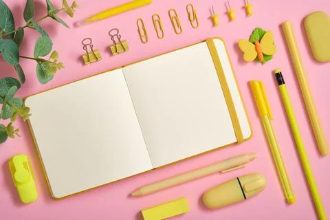 Blank notebook page for text in frame of yellow stationery set on pink back Stock Photos
