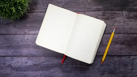 Blank notebook page turning on dark wood surface with yellow pencil and gre.. Stock Footage 332578690