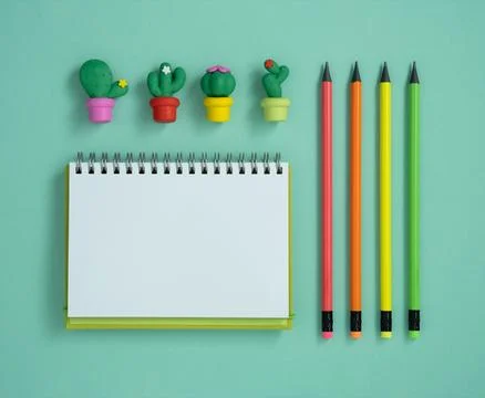 Blank notebook page for your text, colorful pencils and erasers in form of .. Stock Photos
