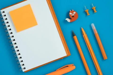 Blank notebook page for your text with orange pen and pencil Stock Photos