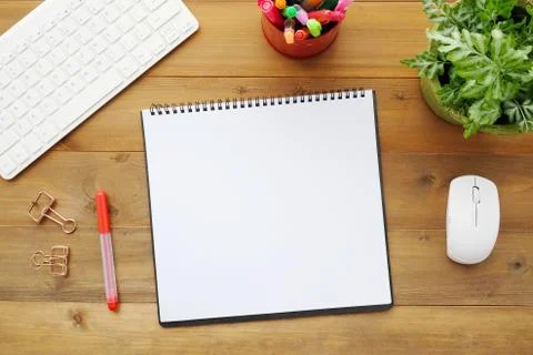 Blank notebook paper, keyboard, mouse and pens on wood table background Stock Photos