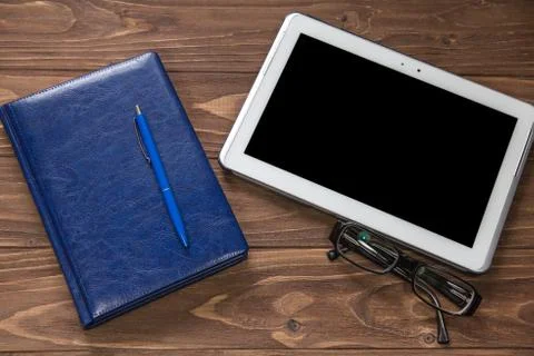 Blank notebook with pen and tablet computer on wooden brown table Stock Photos