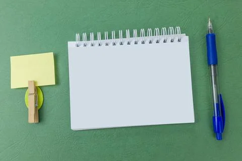 Blank notebook with a pen on green background. Your text here Stock Photos