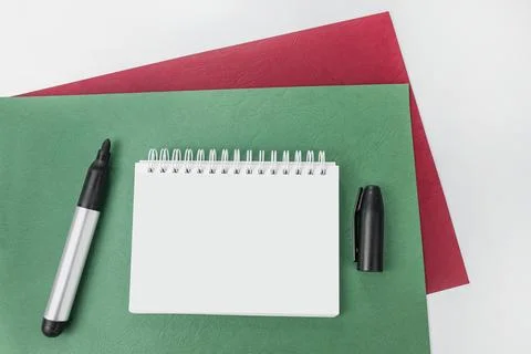 Blank notebook with a pen on green background. Your text here Stock Photos