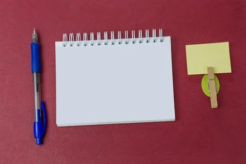 Blank notebook with a pen on red background. Your text here Stock Photos