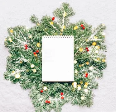 Blank notebook for planning goals on New Year's green branches with lights Stock Photos