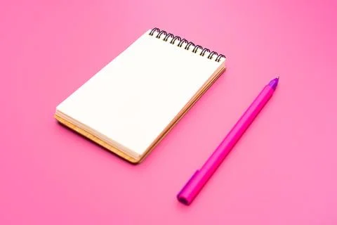 Blank notebook with spiral for the application of labels and pen on pink back Stock Photos