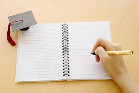 Blank notebook on the table and graduation cap Stock Photos