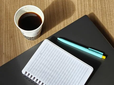 A blank notebook on top of a closed laptop. Stock Photos