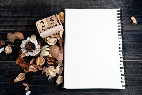 Blank notebooks are placed on a table with dried leaves and wooden block cale Stock Photos