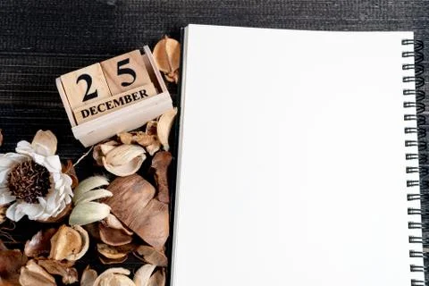 Blank notebooks are placed on a table with dried leaves and wooden block cale Foto stock