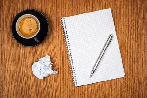 Blank notepad and coffee cup on office wooden table Stock Photos