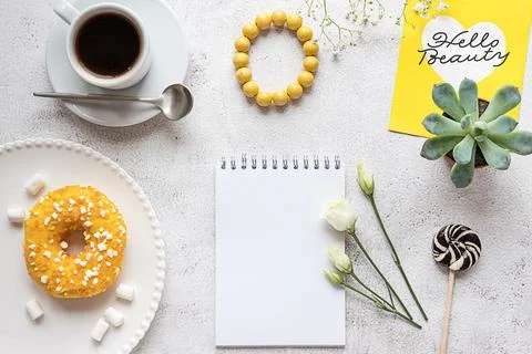 A blank notepad with breakfast setting and plants. Copy space. Stock-Fotos
