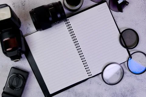 Blank notepad with camera and lenses on a white background. Stock Photos