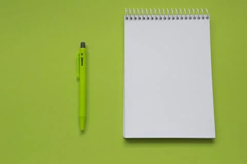 Blank notepad with green pen on light green background Stock Photos