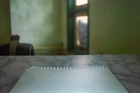 Blank notepad on a marble desk with a blurred room backdrop, ideal for mock.. Stock Photos
