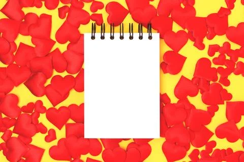 Blank notepad mockup and red textile hearts confetti. Stock Photos