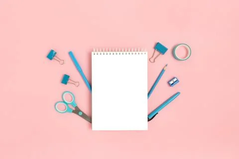 Blank notepad mockup with blue office supplies on a pink pastel background. Stock Photos