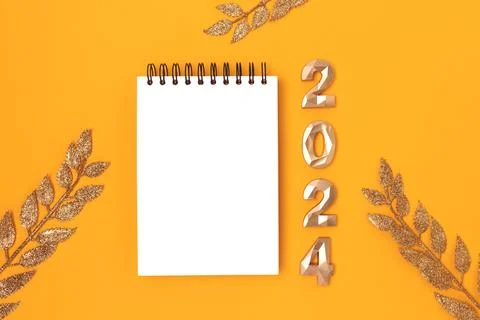 Blank notepad mockup, glittering decorative branches and 2024 golden numbers. Stock Photos