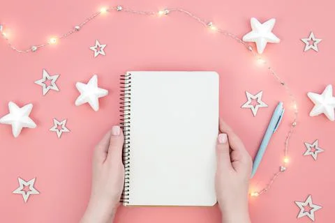 Blank notepad on pink background and decorative stars and garland, flat lay. Stock Photos