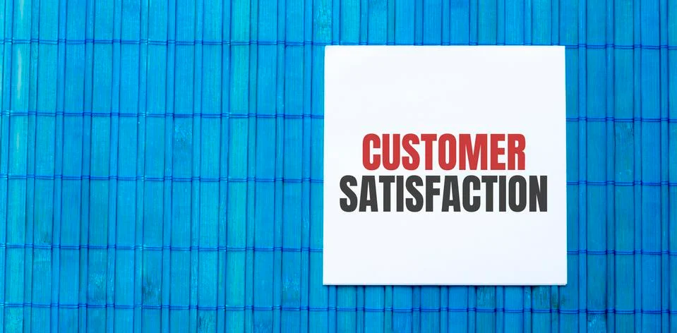 Blank notepad with text Customer Satisfaction on green wooden background Stock Photos