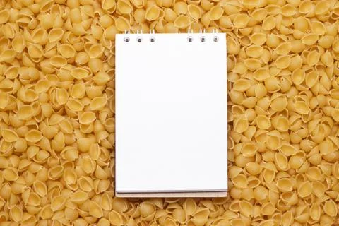 Blank notepad on uncooked macaroni background Stock Photos