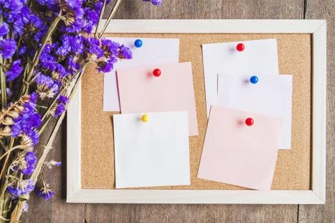 Blank notes on the cork board with dry flower bouquet,wooden background. Stock Photos