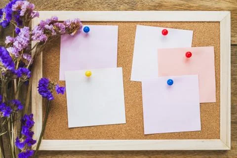 Blank notes on the cork board with dry flower bouquet,wooden background. Stock Photos