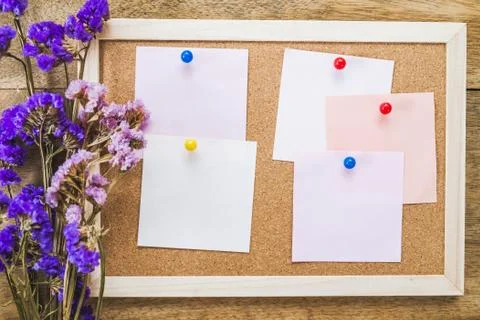 Blank notes on the cork board with dry flower bouquet,wooden background. Stock Photos