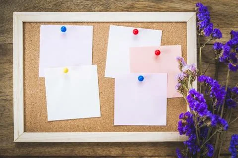 Blank notes on the cork board with dry flower bouquet,wooden background. Stock Photos