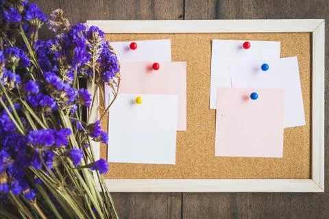 Blank notes on the cork board with dry flower bouquet,wooden background. Stock Photos