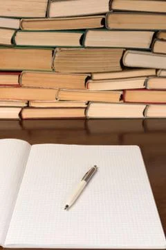 Blank open notepad with pen on the table with books background Stock Photos